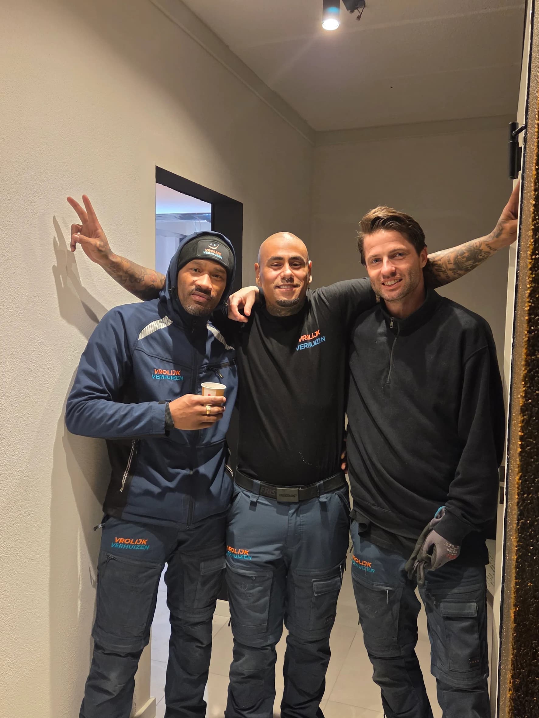 Three Vrolijk Verhuizen crew members in workwear ready for the jobs at home