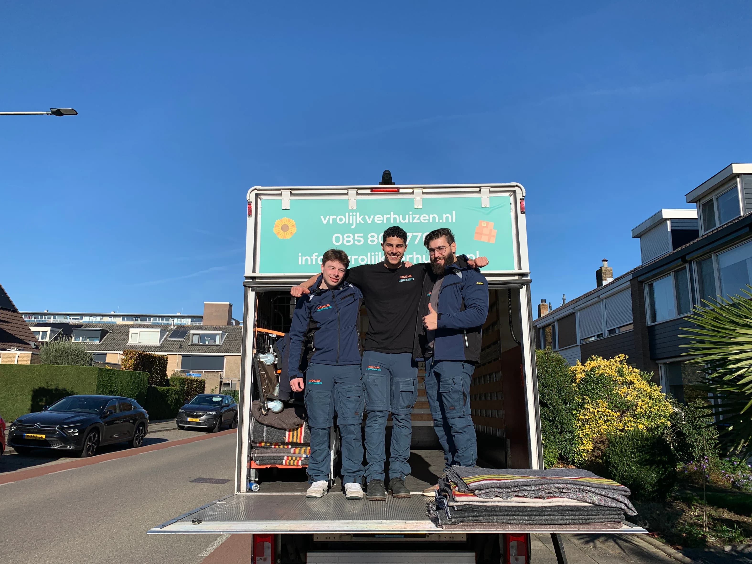 Vrolijk Verhuizen verhuizers met alles klaar bij de laadklep