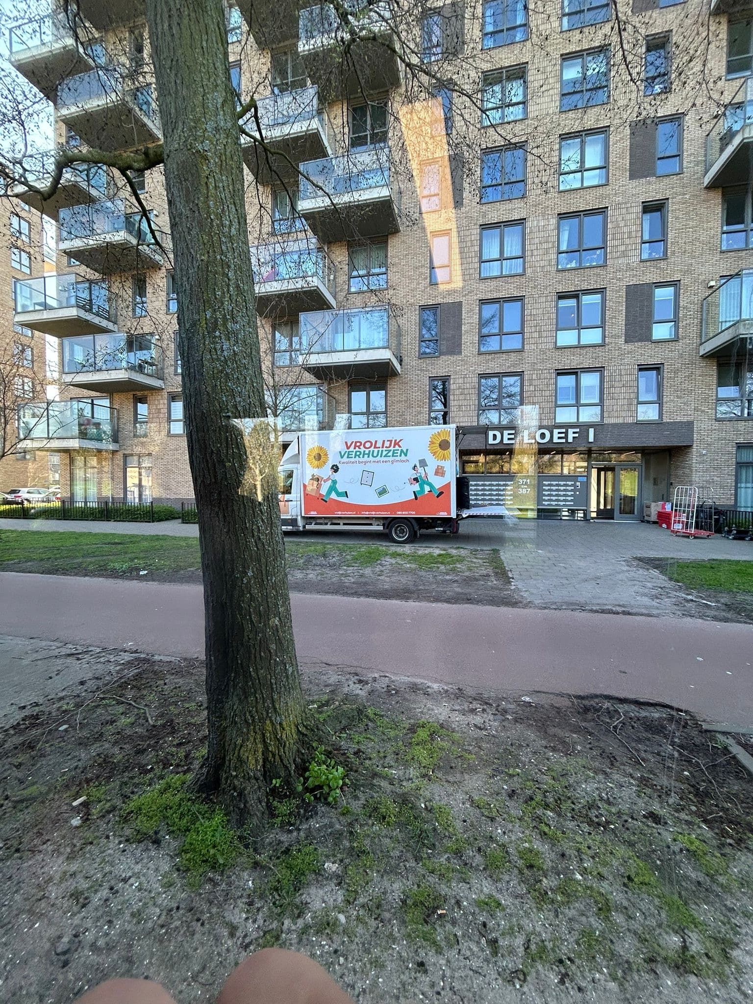 Vrolijk Verhuizen van next to an office building during a business move