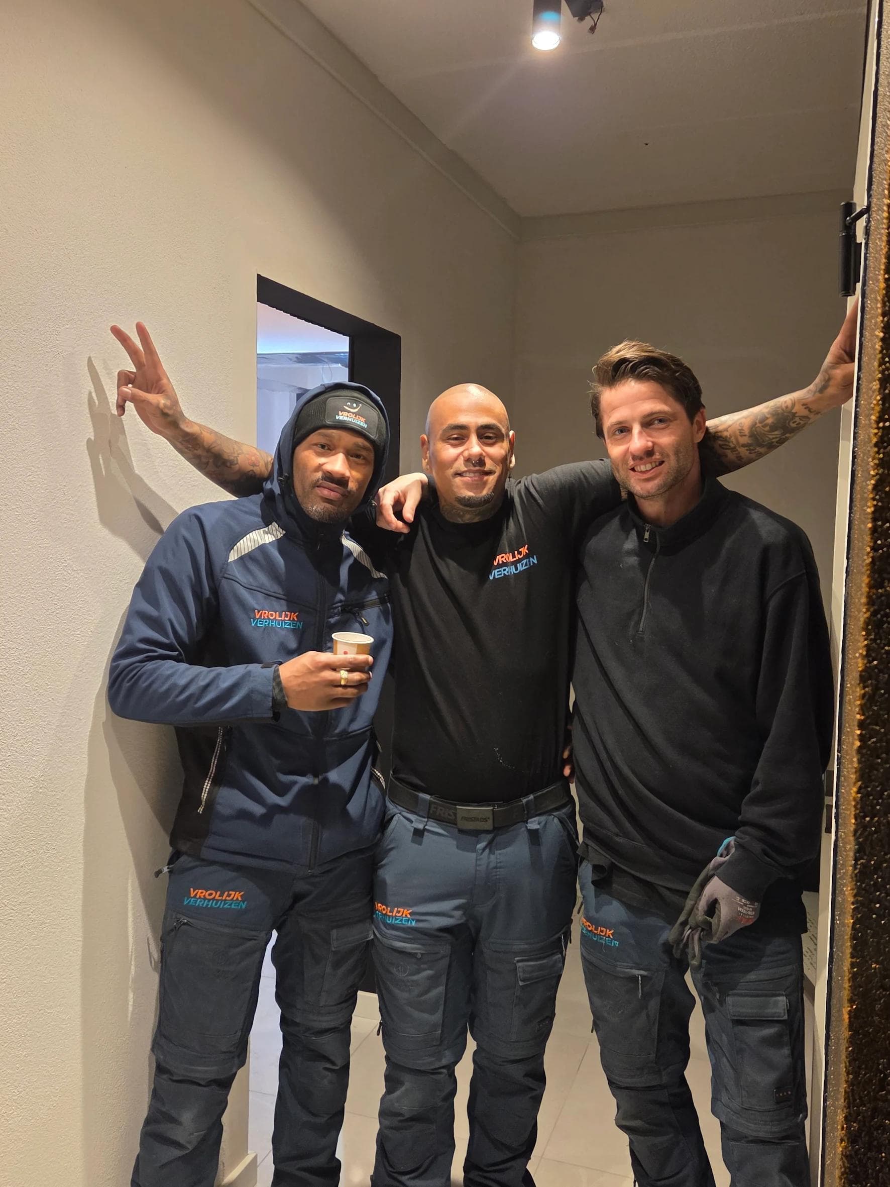 Drie Vrolijk Verhuizen crewleden in werkkleding klaar voor de klussen in huis