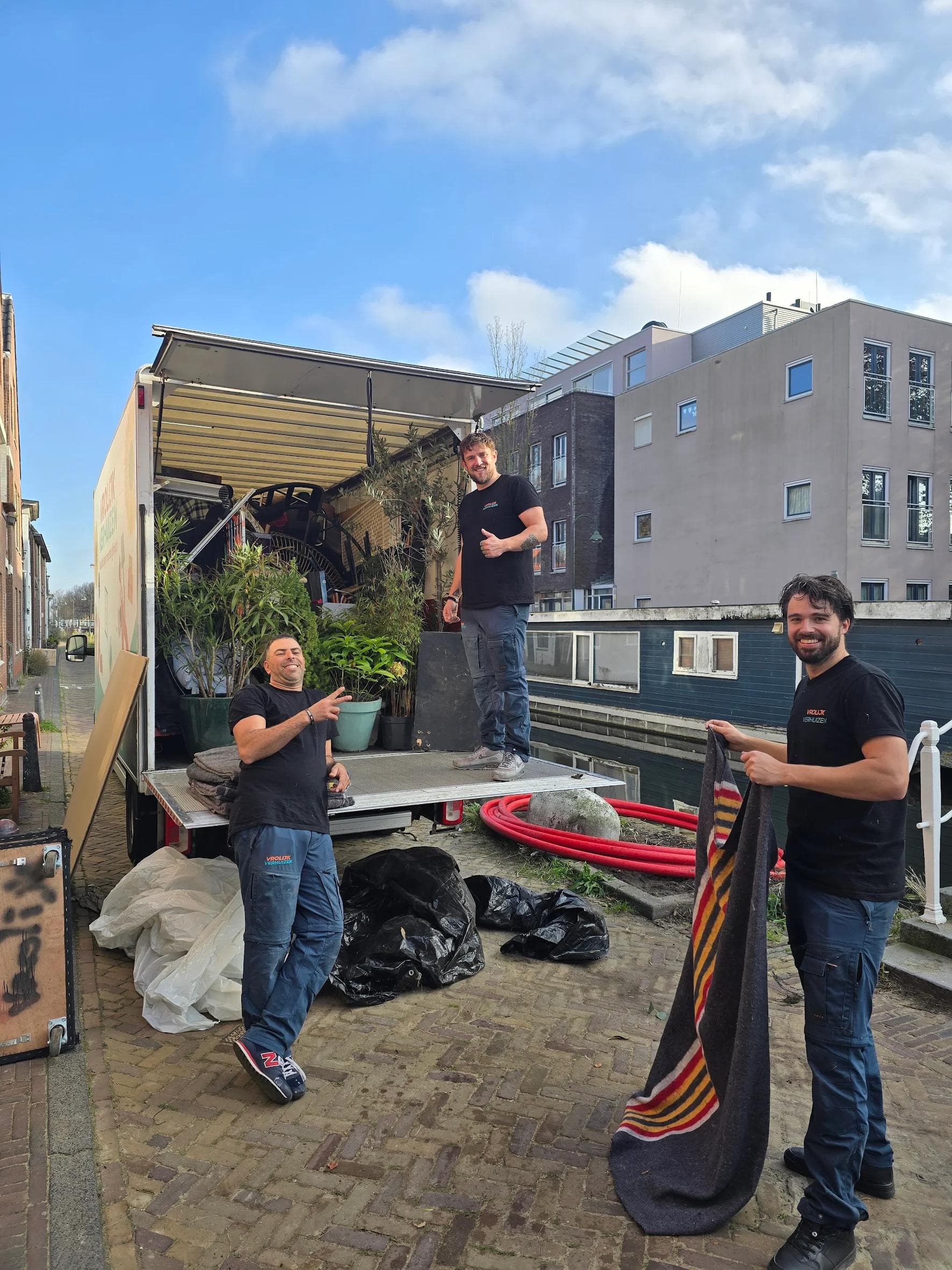 Vrolijk Verhuizen crewleden die een meubelstuk hanteren